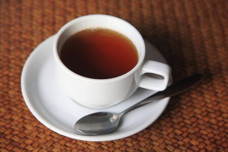 Cup of hot tea on weave wooden table backgroundの写真素材
