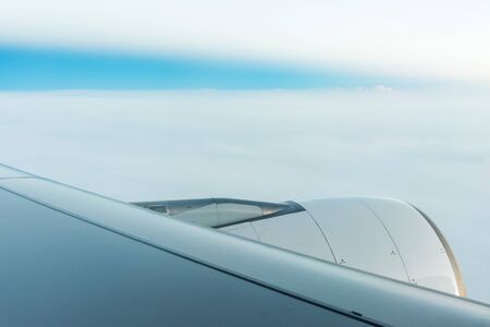 Jet engine on Plane wing flying above the cloudsの写真素材