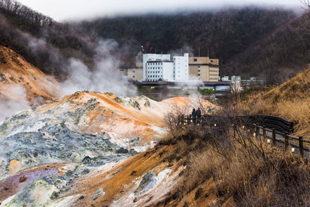 Couple sightseeing Jigokudani hell valley at late evening in Noboribetsu, Hokkaido, Japanのeditorial素材