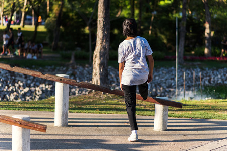 Rear shot of runner woman stretching leg for exercise in parkの写真素材