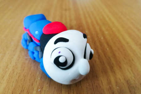 Front view of little blue Thomas train made by clay on wooden tableの写真素材