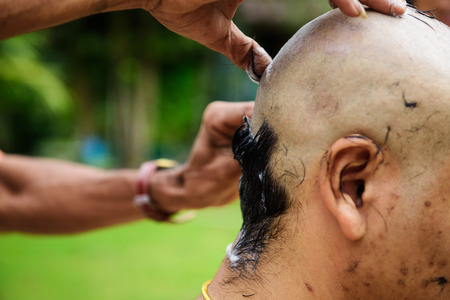 Shaving hair for Buddhist ordination ceremony in Thailand with natural garden background. Preparation for new Thai monk.の写真素材