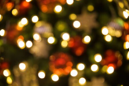 blurred bokeh abstract background of Christmas or xmas tree with light bulbs and snow flake.の写真素材