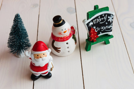 Christmas background with decorations of santa claus, snow man, tree, and Merry xmas sign, on white wooden board backdrop with copy space for text. 2018 New year celebration.の写真素材