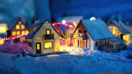 miniature houses in the village with snow at night with light up decoration. Christmas winter model for holiday background.の写真素材