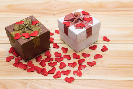 Two couple gift box with full of hearts and fake snow on wood with copy space for text. Valentine Concept for shopping present online during winter season for sweet couple.の写真素材
