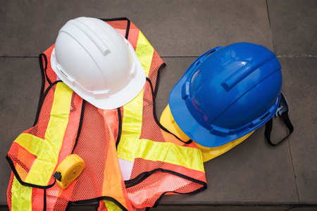 Top view or flat lay of Safety helmet hats, measure tape,  and worker dress on concrete floor at modern city. Engineer and construction equipment with copy space for text.の写真素材