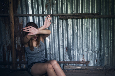 Sexual harassment or rape concept. Close up woman two hands protect herself from bad guy to be raped and suffered sex abuse in abondon house with blurred background and copy space for text.の写真素材