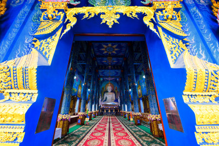 Main entrance to big Buddha statue and beautiful traditional hand craft at Wat Rong Sua Ten, blue temple, Chiang Rai, Thailand. Foriengn language means 'Please donate' in Thai.のeditorial素材