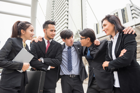 Group of International Happy Business team hands holding each other shoulder and smiling together to cheer up in urban city. Multi ethnic Teamwork to success project.の写真素材