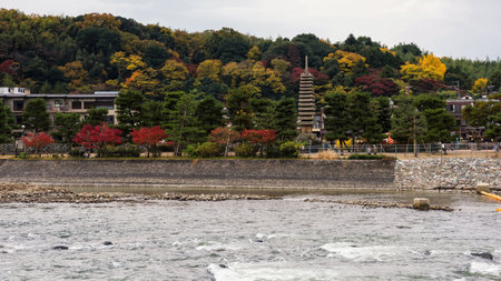 Uji, Kyoto, Japan - November 20, 2016: Unidentified people at famous Uji thirteen storied pagoda with autumn foliage colors near river.のeditorial素材