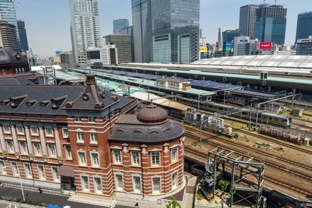 Tokyo, Japan - May 8, 2017: Antique Tokyo station and JR local and bullet trains, aka Shinkansen, parking at station with modern city skyline view.のeditorial素材
