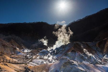 Noboribetsu natural landmark, Jigokudani hell valley with sulfur misty against sunrise and blue sky, Hokkaido, Japan. Travel destination around On-sen or Onsen area.のeditorial素材