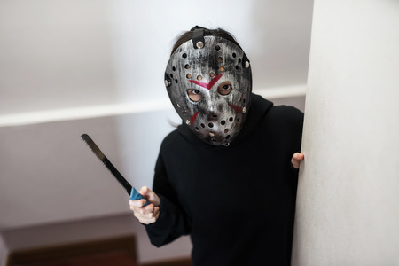 Female model with Jason mask and black dress costume hold knife on hand. Scary human for 2018 Halloween concept with copy space for text.の写真素材