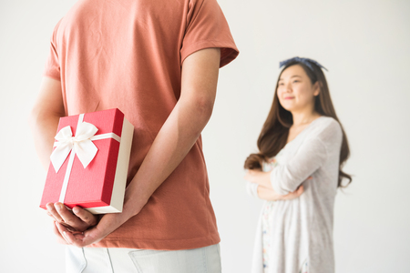 boyfriend hold and hide surprise valentine gift box to his beauty Chinese Asian girlfriend with copy space for text.の写真素材