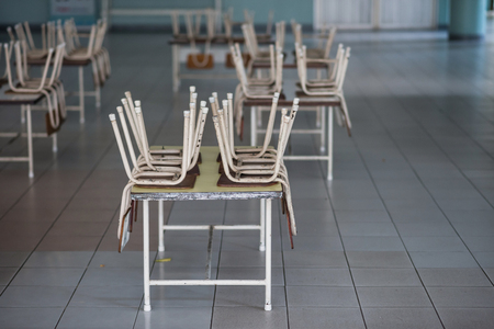 Many chairs on tables in kindergarten room. empty classroom without any student. End of school semester concept.の写真素材