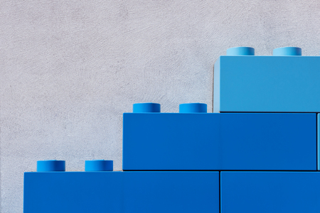 Big blue plastic building blocks near wall. Outdoor exterior decoration at Children amusement with copy space for text.の写真素材