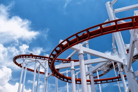 Closeup red roller coaster against clear blue sky at amusement park with copy space for text.の写真素材