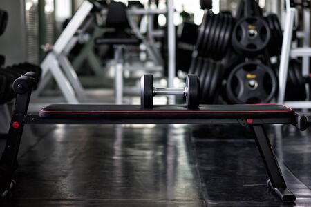 dumbbell on multifunction bench for abdominal and lifting in fitness gym. Healthy lifestyle and bodybuilding at modern sport club.の写真素材