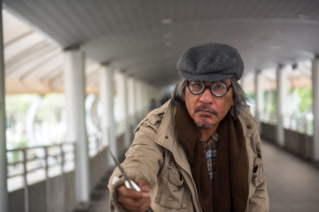 Old man attack with knife. Senior homeless guy with the knife in hand ask for money in city. Concept...