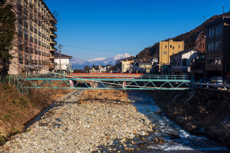 Shibu onsen city and central alps mountain with blue sky, Yamanouchi, Nagano, Japan. The town is...