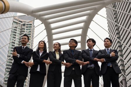 International business team gather and shake hands in modern city for success of project cooperation. multi culture of business people, American, Arab, Chinese, and Thai.の写真素材