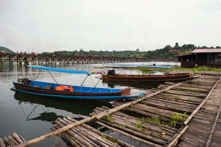 Wooden motor tourist boats near raft house with Mon wood bridge background at Song Kalia river, Sangkhlaburi, Kanchanaburi, Thailand. Famous travel destination landmark.のeditorial素材