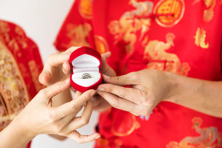 Closeup engagement ring diamond. Chinese couple dress red traditional cheongsam costume during 2020...