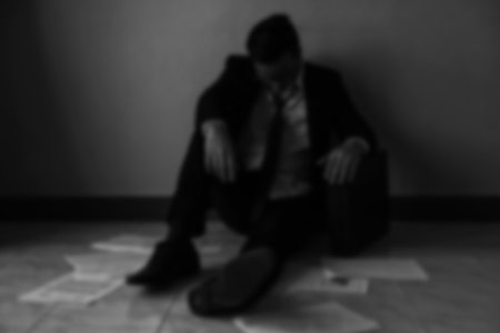 Blurred abstract of sad businessman get fired from work due to COVID-19 or corona-virus impact with copy space. Global business impact from pandemic virus claimed by WHO. black and white process.の写真素材
