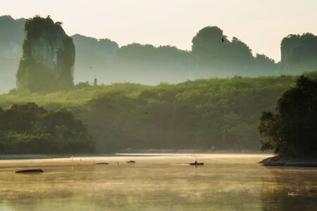 Silhouette Fisherman on boat fishing on lake with fog or mist at morning sunrise in NongTalay or Nong Talay, Krabi, Thailand. Famous travel destination in south of Thai.の写真素材