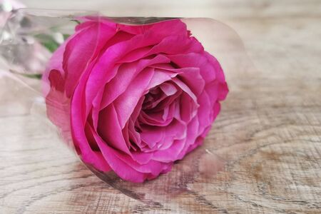 Closeup pink rose bouquet on wooden table background. Love, marriage anniversary, valentine, wedding decoration concept.の写真素材