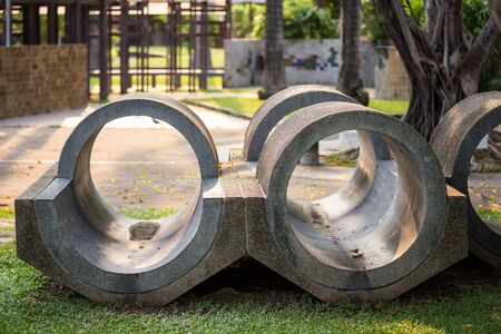 Children activity concrete hole tunnel for kid muscle leg, foot, hand development in playground at sunset.の写真素材