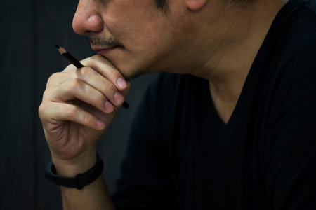 unshaven beard Asian business man hold pencil and think. Stay and work from home during covid-19...