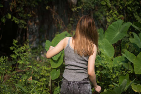 Pity Asian woman get loss in green forest at spring. sad girl miss footpath walking trail into deep wood.の写真素材
