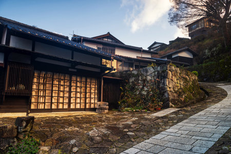 Uphill walking trail at Magome juku preserved town of Nakasendo in morning, Kiso valley,  Nakatsugawa, Gifu, Japan. Famous travel destination to visit preserved town. House against sunrise light.のeditorial素材