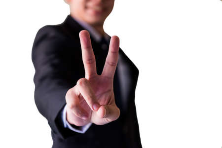 Smiling Asian young businessman with glasses and suit show victory hand gesture isolated on white background. Success or achievement concept. Closeup on 2 fingers sign.の写真素材