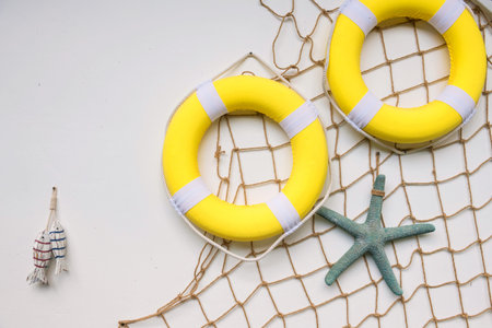 White wall decorated with yellow swim rings, starfish, fish, and fishnet. Beach sea and summer...