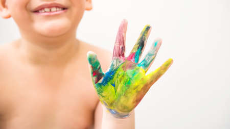 Colorful paint hand of blur smiling boy isolated on white background. Art work concept.の写真素材