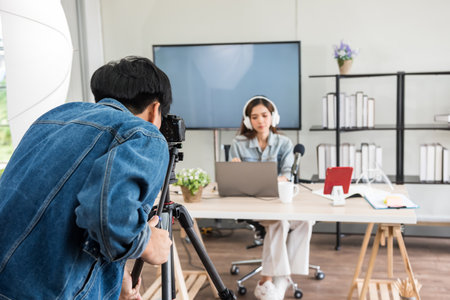 Behind the scene concept. Videographer record footage to streaming live online of young Asian women blogger with studio lighting. broadcasting vlogger content of internet influencer.の写真素材