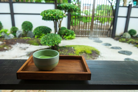 Macha green tea on wooden table with traditional Japanese gardenの写真素材