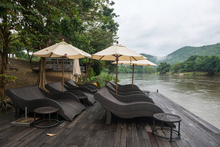 Relax seats at wooden port by kwai river in morning with mist in Kanchanaburi, Thailand.の写真素材