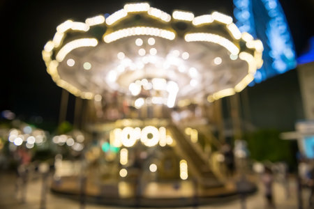 Blur image of beautiful bright carousel or merry go round light up in amusement parkの写真素材