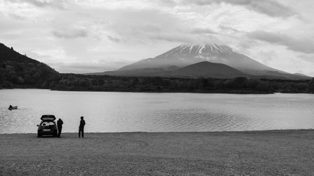 male photographers take picture of lake shoji and mount Fuji near mini suv car, Yamanashi, Japan. Famous travel and camping in 1 of 5 Fuji lakes. Black and white color process.の写真素材