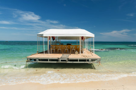 Ferry boat by beach against turquoise sea and blue sky at Ko Man Klang, Rayong, Thailand. Summer...