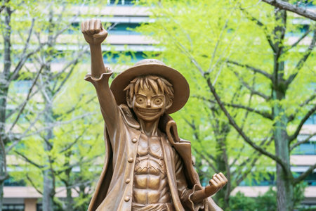 Kumamoto, Japan - April 2, 2024: Closeup Luffy Monkey D. golden statue at Promenade in front of Kumamoto Prefectural Office. Famous character of Japanese Manga comic, One piece.のeditorial素材