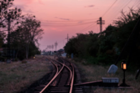 Blur image of railway at dusk with twilight sky in Nakhon Ratchasima or Korat province, Thailand....