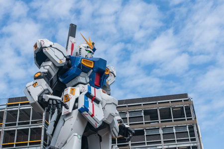 Fukuoka, Japan - April 7, 2024: Closeup Gundam life size RX 93ff Î½ robot statue against blue sky in front of Mitsui Shopping Park LaLaport.のeditorial素材