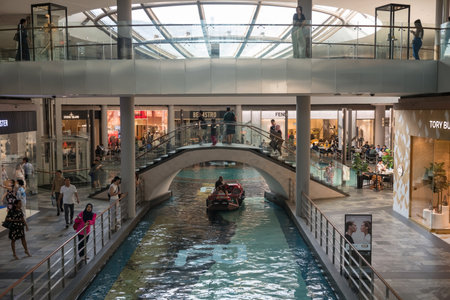 Marina Bay, Singapore - ââOctober 12, 2023: Tourist people enjoying sampan boat ride inside Marina Bay Sands shopping mall.のeditorial素材