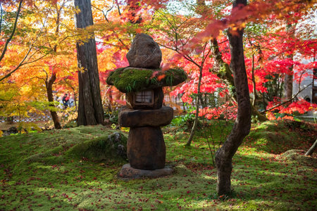 Stone lantern statue decor at colorful autumn foliage garden of Eikando or Eikan-do Zenrinji Temple,...