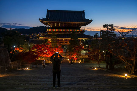 people photo Kurodani Konkai Komyoji temple mountain gate with city view at dusk with twilight sky in autumn, Kyoto, Japan. travel destination for tourist sightseeing Kansai for fall illusion.の写真素材